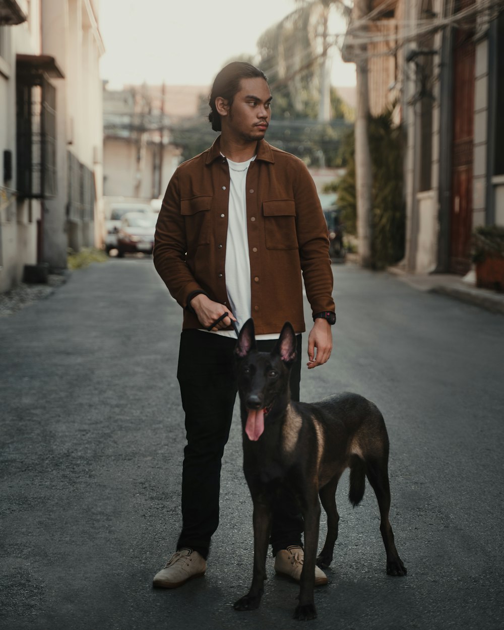 woman in brown leather jacket holding black short coated dog
