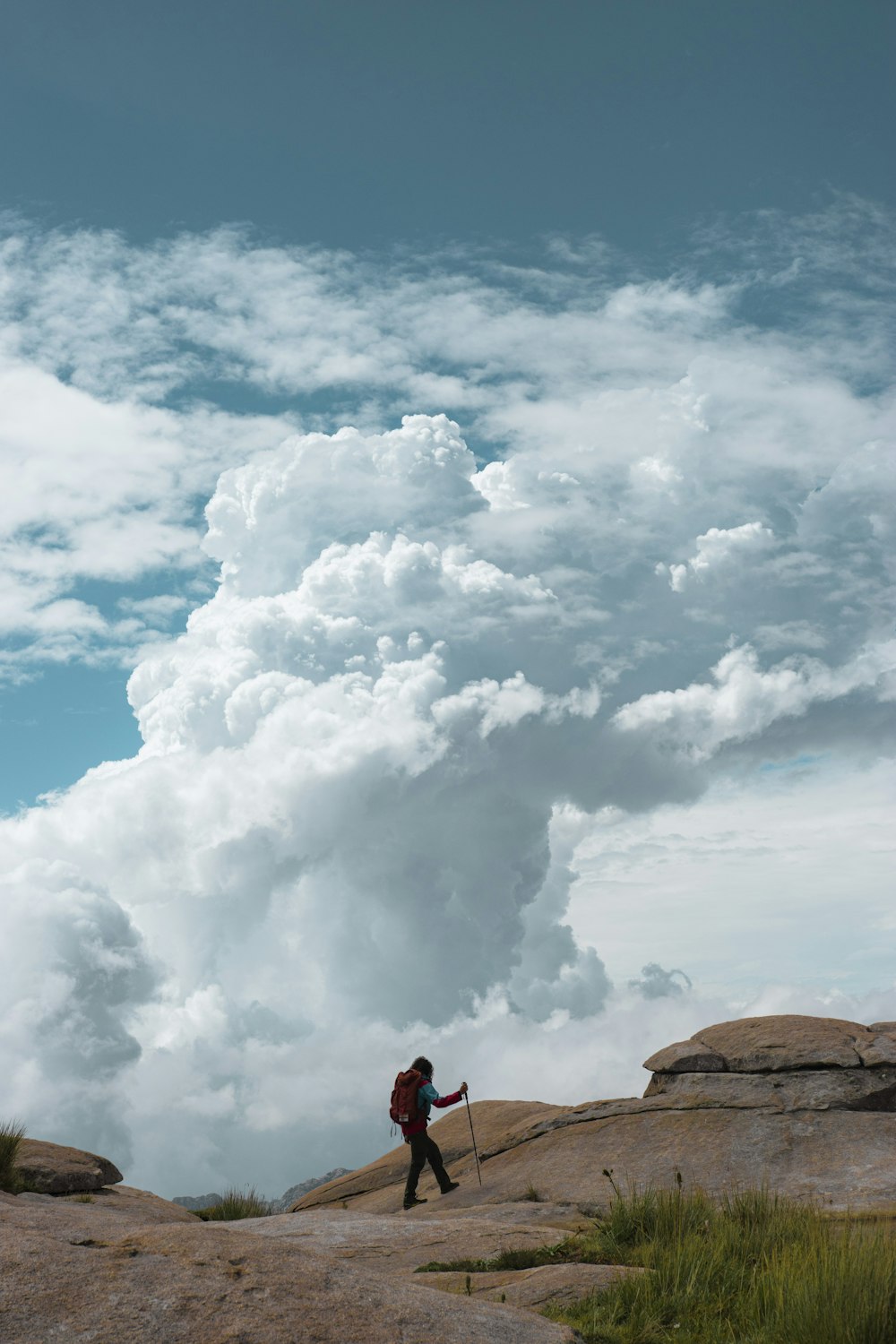 person standing on brown rock under white clouds during daytime