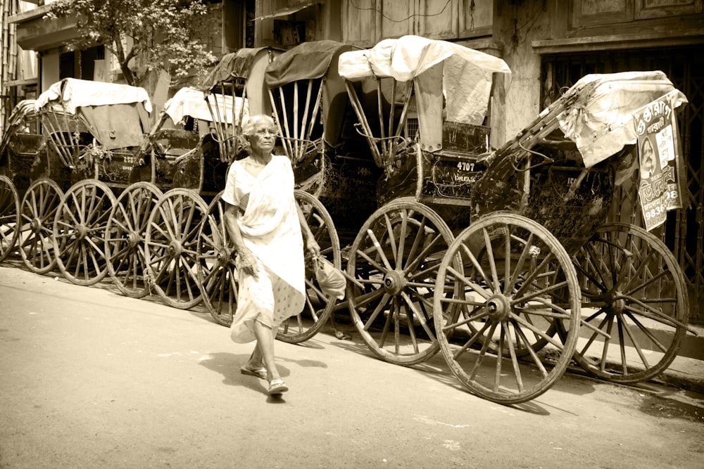 woman in white dress standing beside black and white carriage