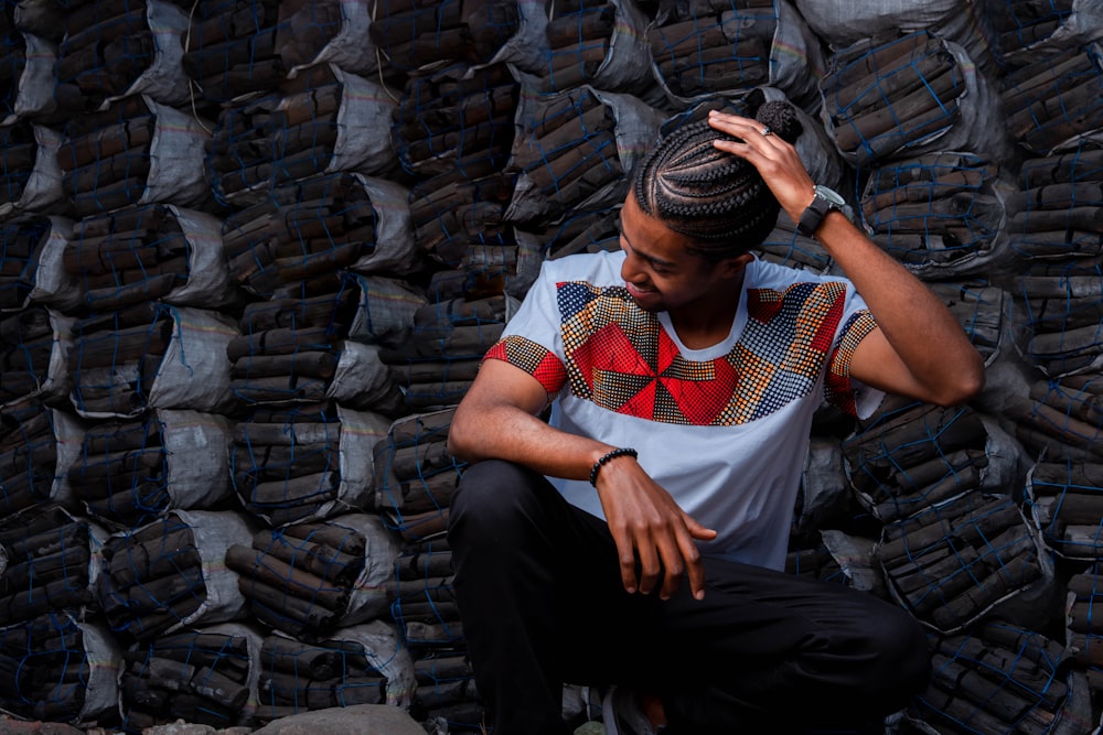 man in white red and blue crew neck t-shirt sitting on black concrete bench