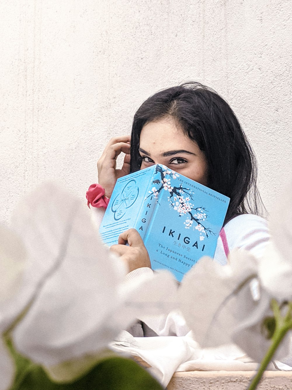 woman in white long sleeve shirt holding blue card