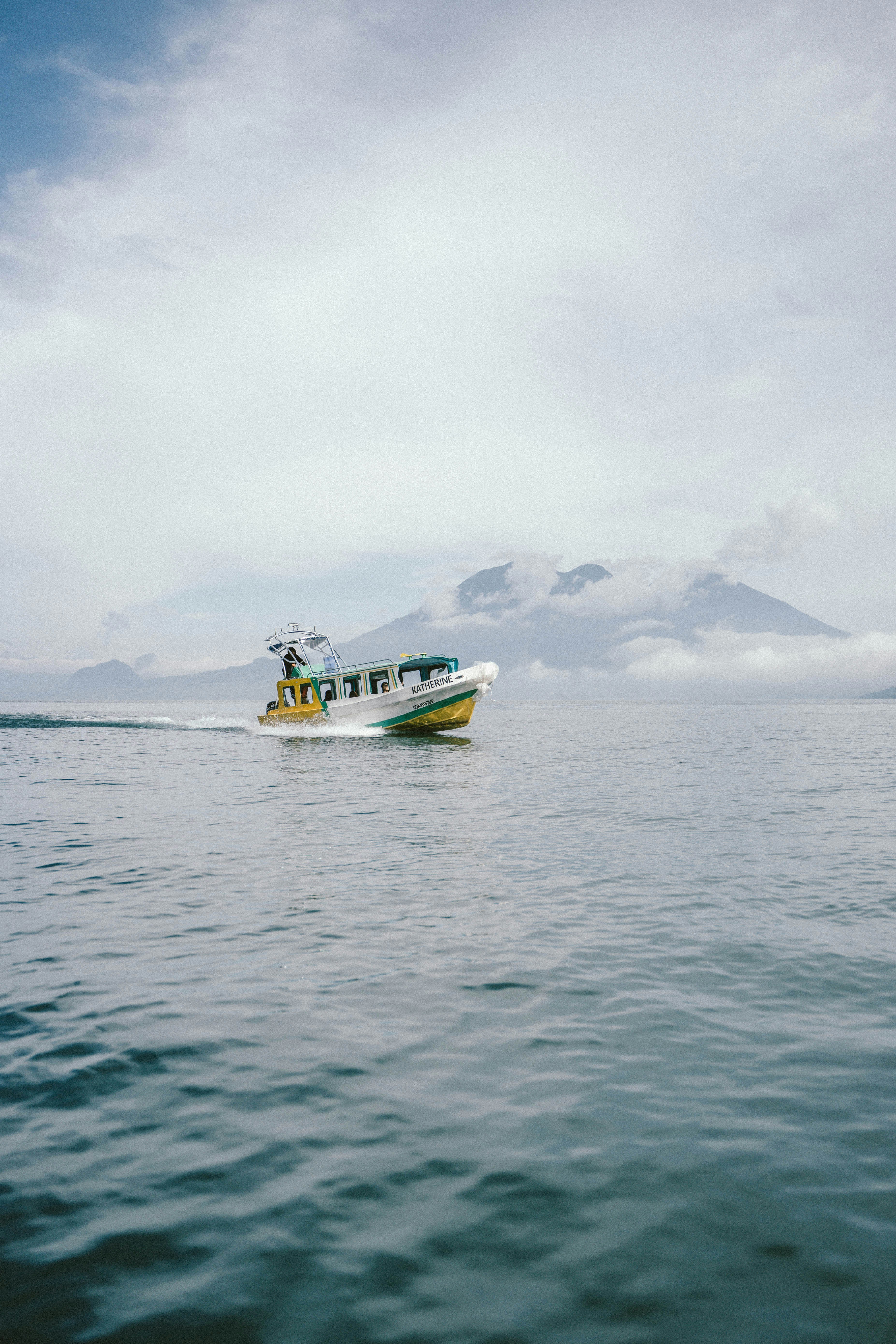 barco branco e amarelo no mar durante o dia