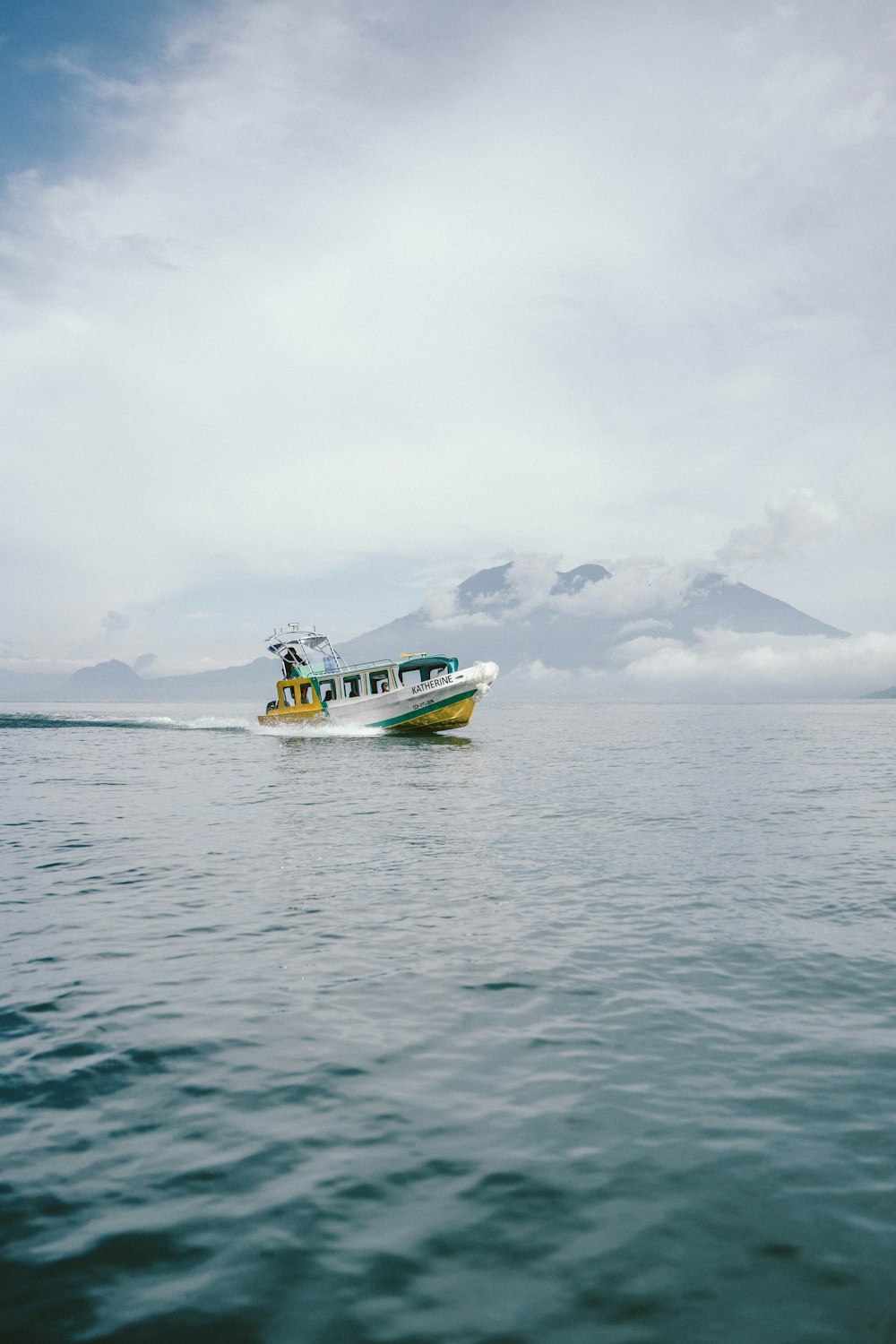 white and yellow boat on sea during daytime