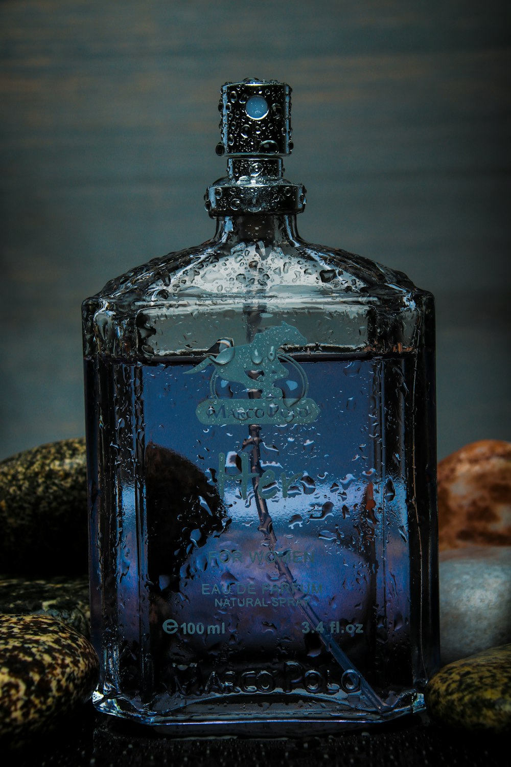 blue glass bottle on black and white textile