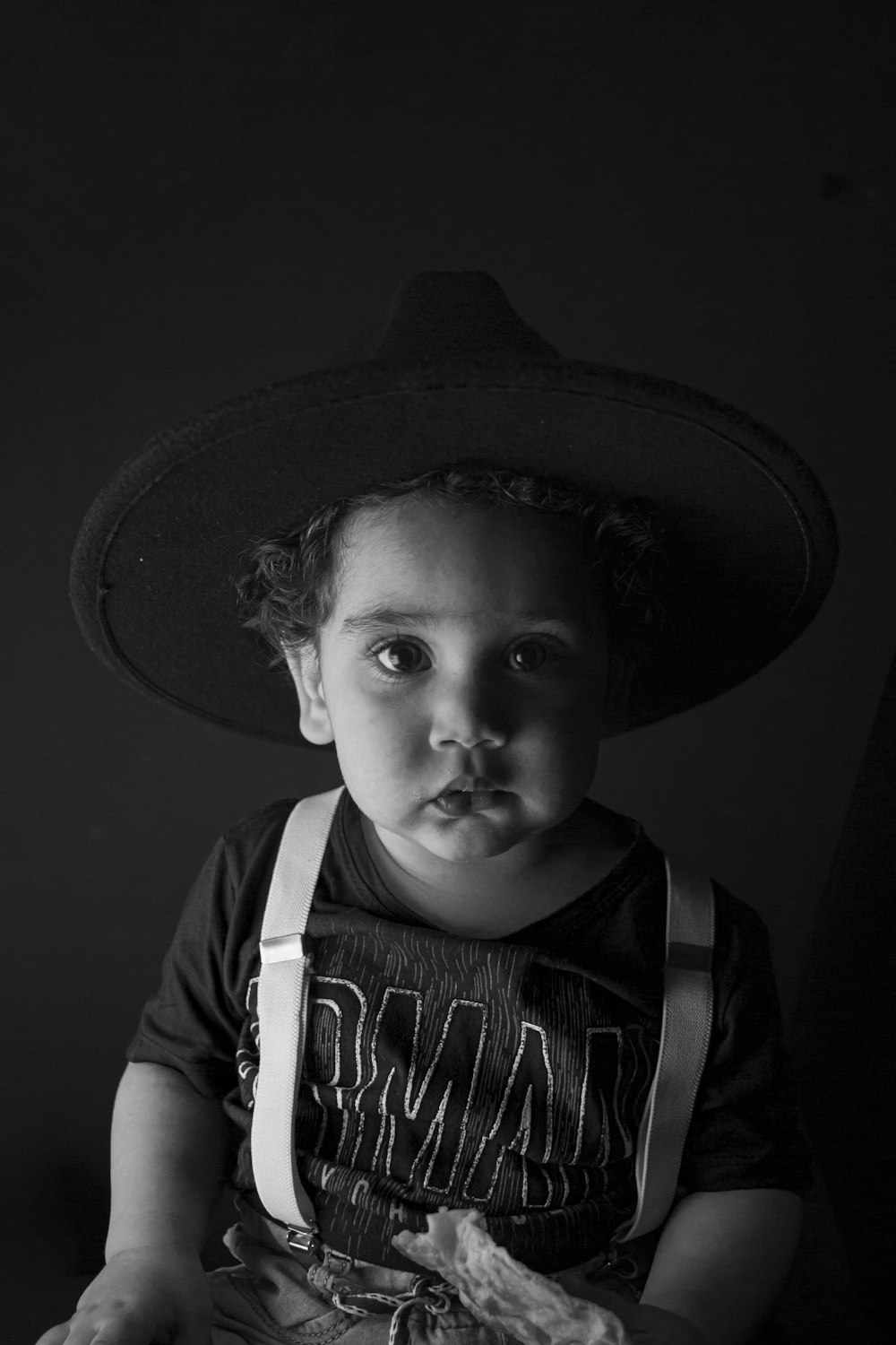 grayscale photo of child wearing hat