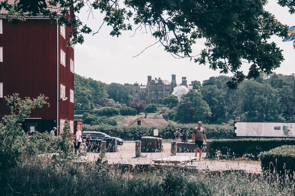 Menschen, die tagsüber in der Nähe des roten Gebäudes stehen