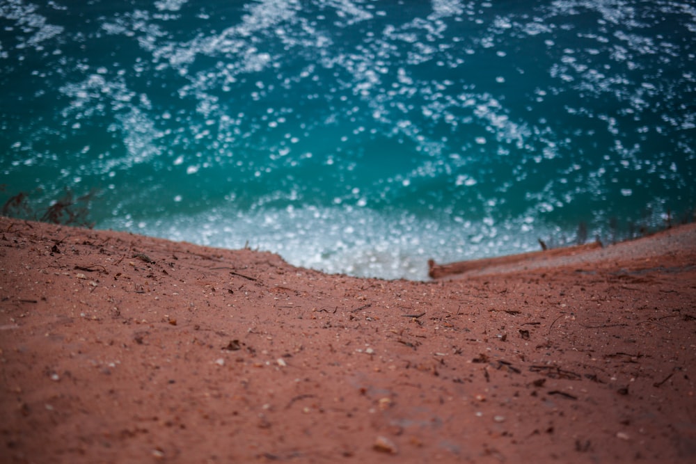 brown sand near blue body of water during daytime