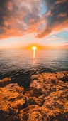 brown rocky shore during sunset