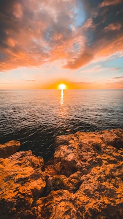 brown rocky shore during sunset