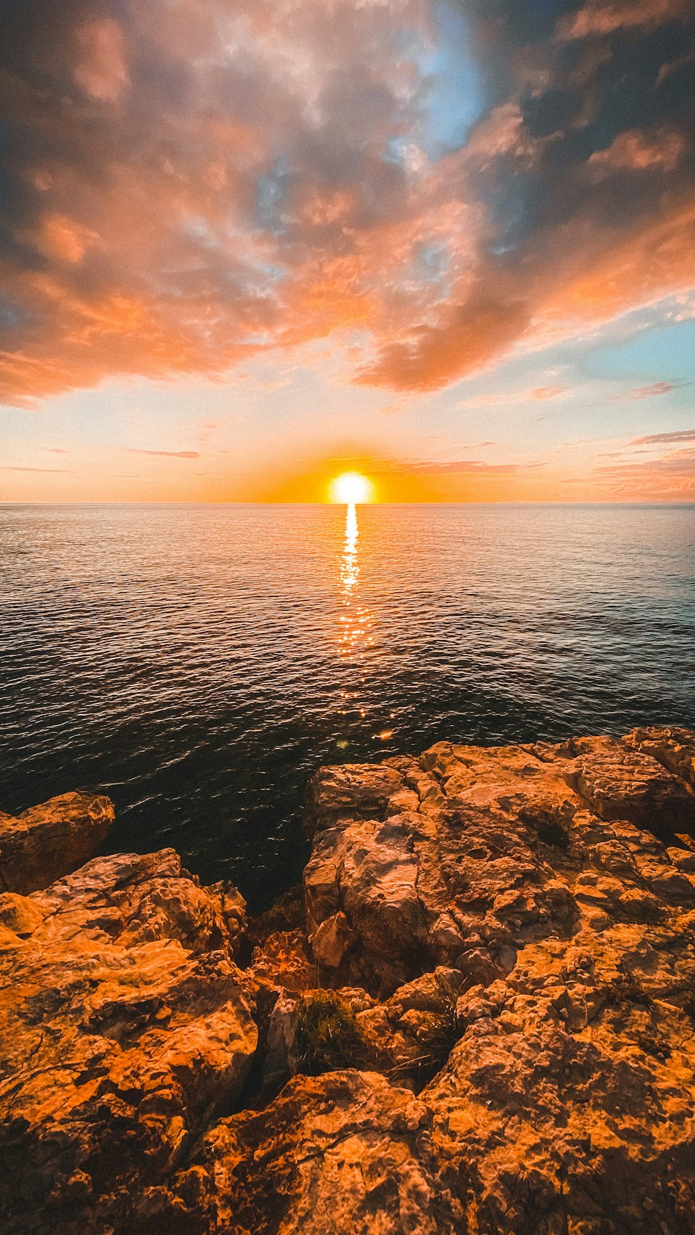 Costa rocosa marrón durante la puesta de sol