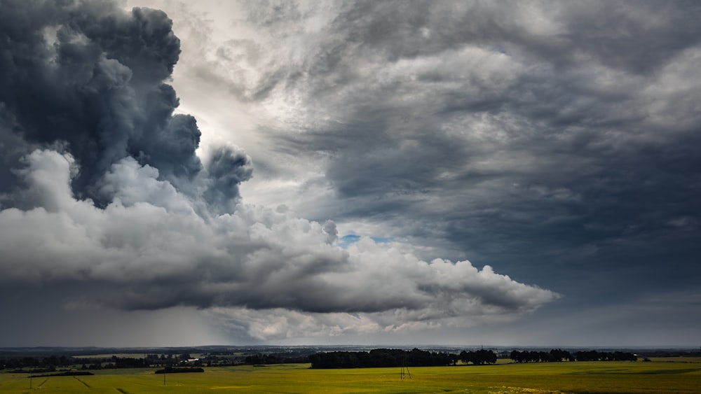 white clouds over green grass field during daytime