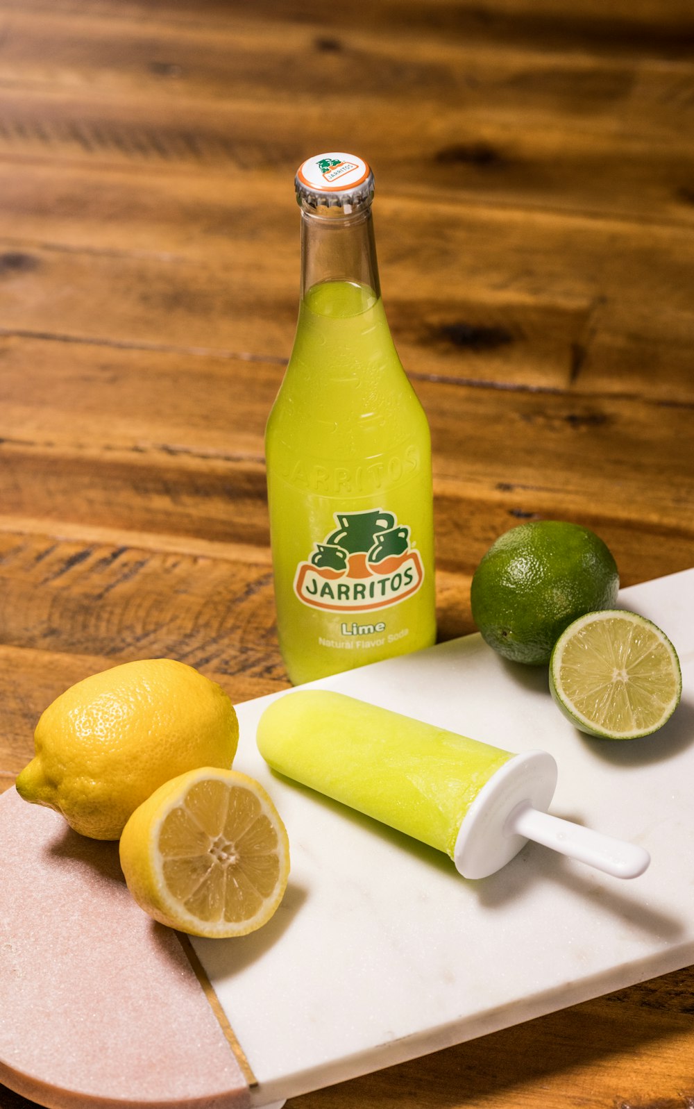 bottiglia di succo di lime al limone giallo accanto al limone a fette