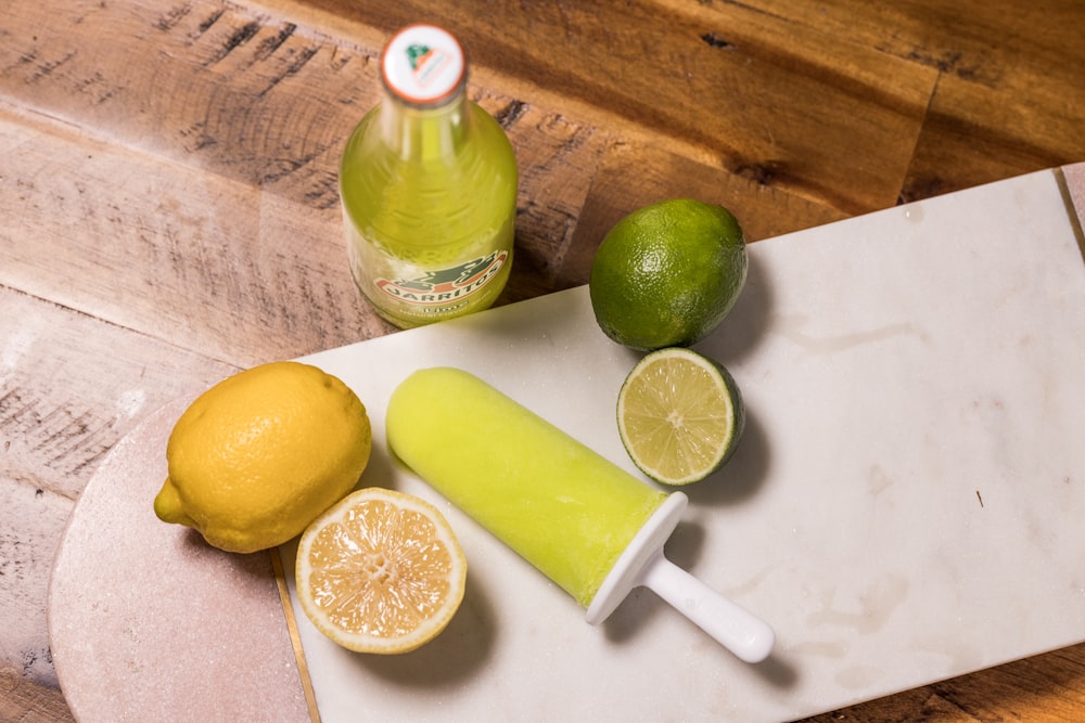 sliced lemon beside green glass bottle