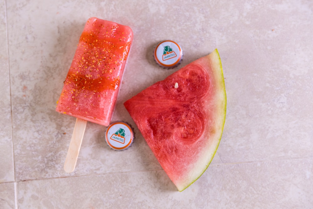 sliced watermelon beside white and blue round container
