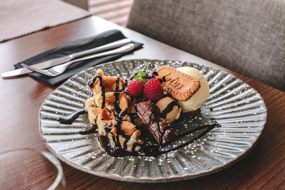 chocolate cake with strawberry and blueberry toppings on clear glass plate