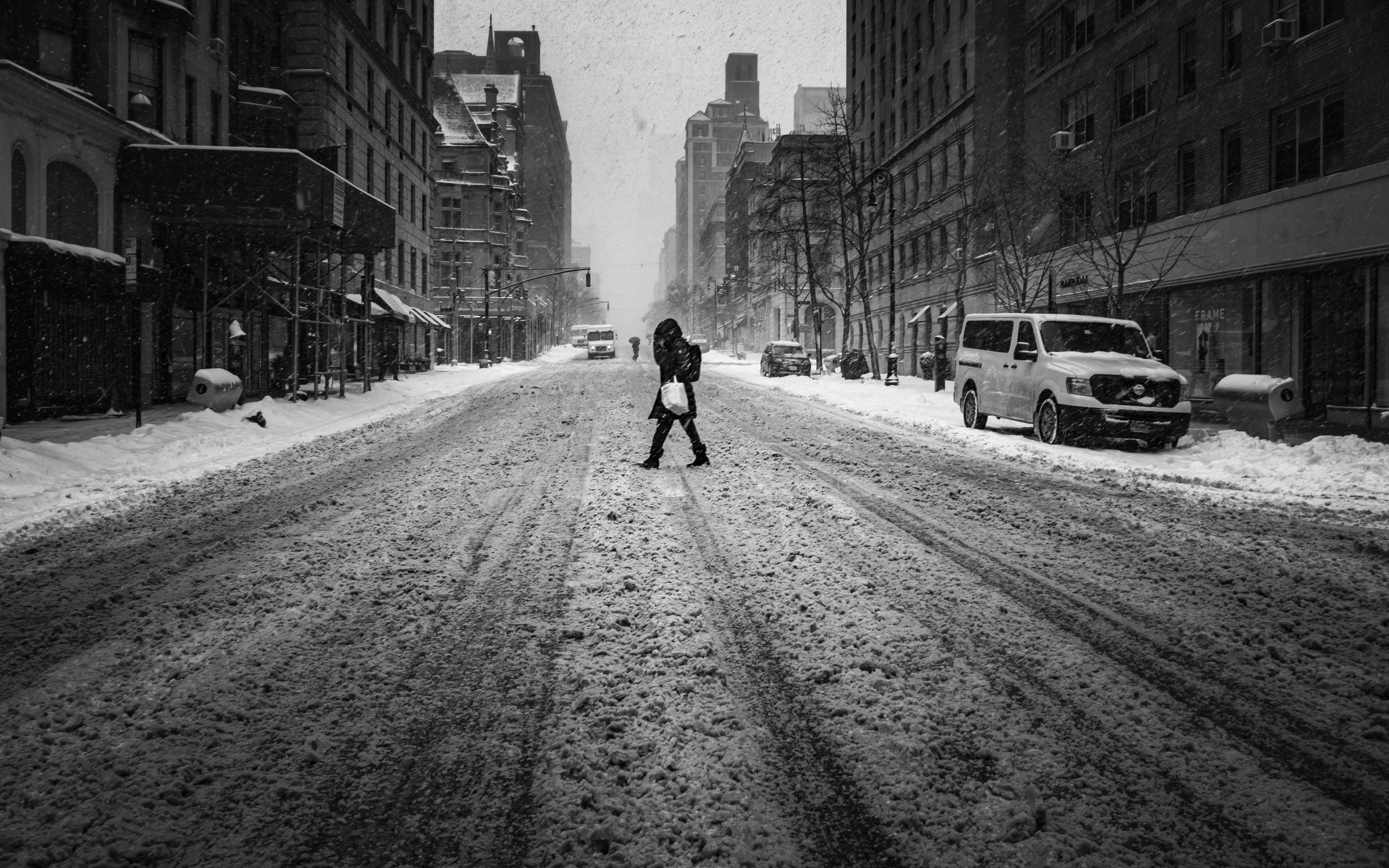 A person crosses the street during blizzard in Manhattan.