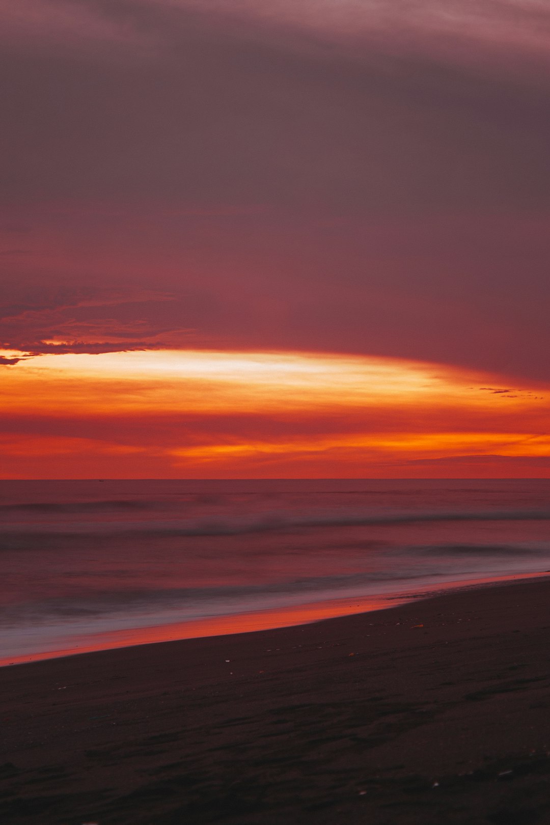 ocean waves crashing on shore during sunset