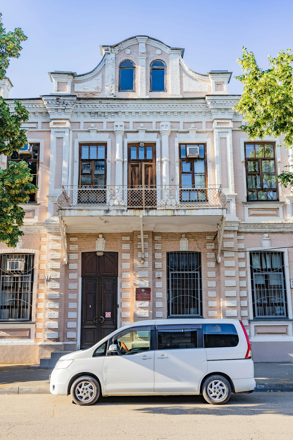 white car parked in front of brown concrete building