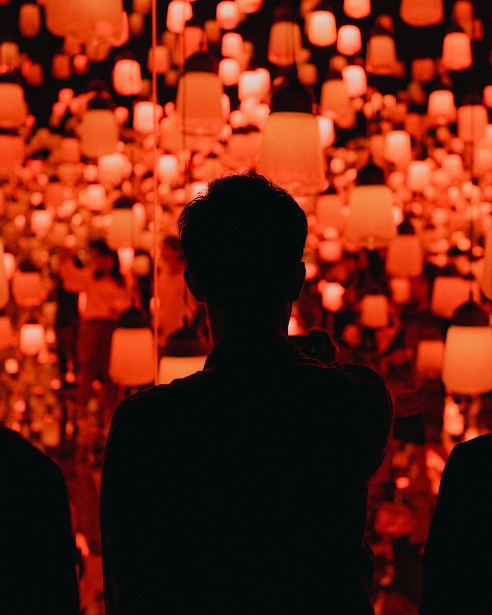 silhouette of people standing near lighted candles during night time