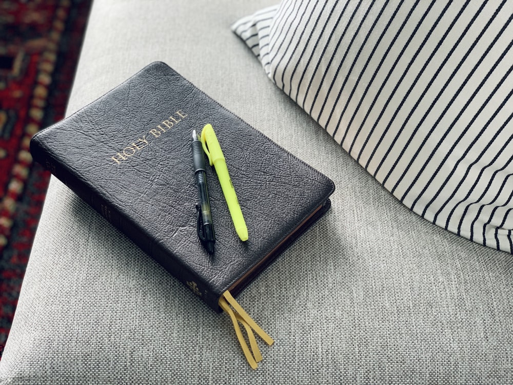 Bolígrafo de clic negro y verde en cuaderno negro