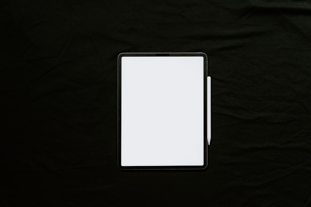 white tablet computer on black textile