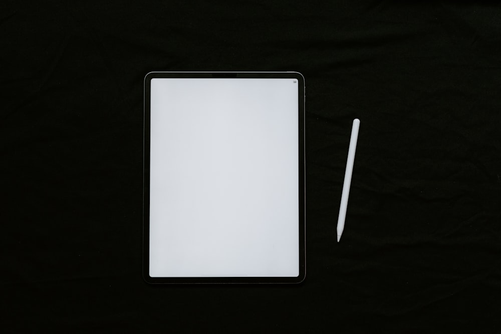 white tablet computer on black textile