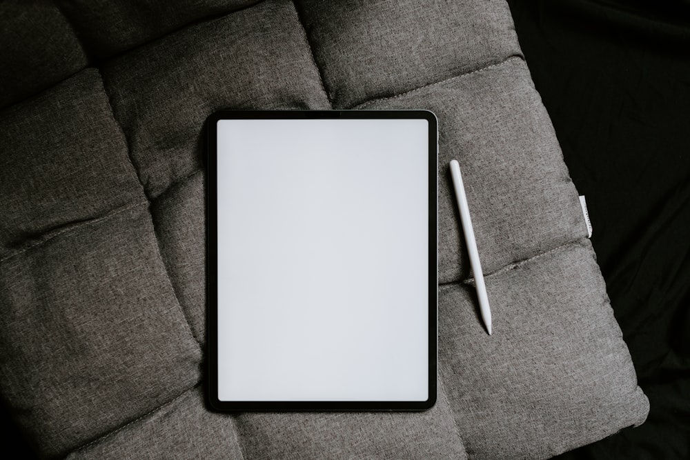 white tablet computer on gray textile