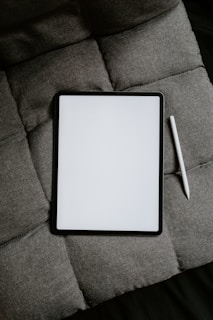 white tablet computer on gray textile