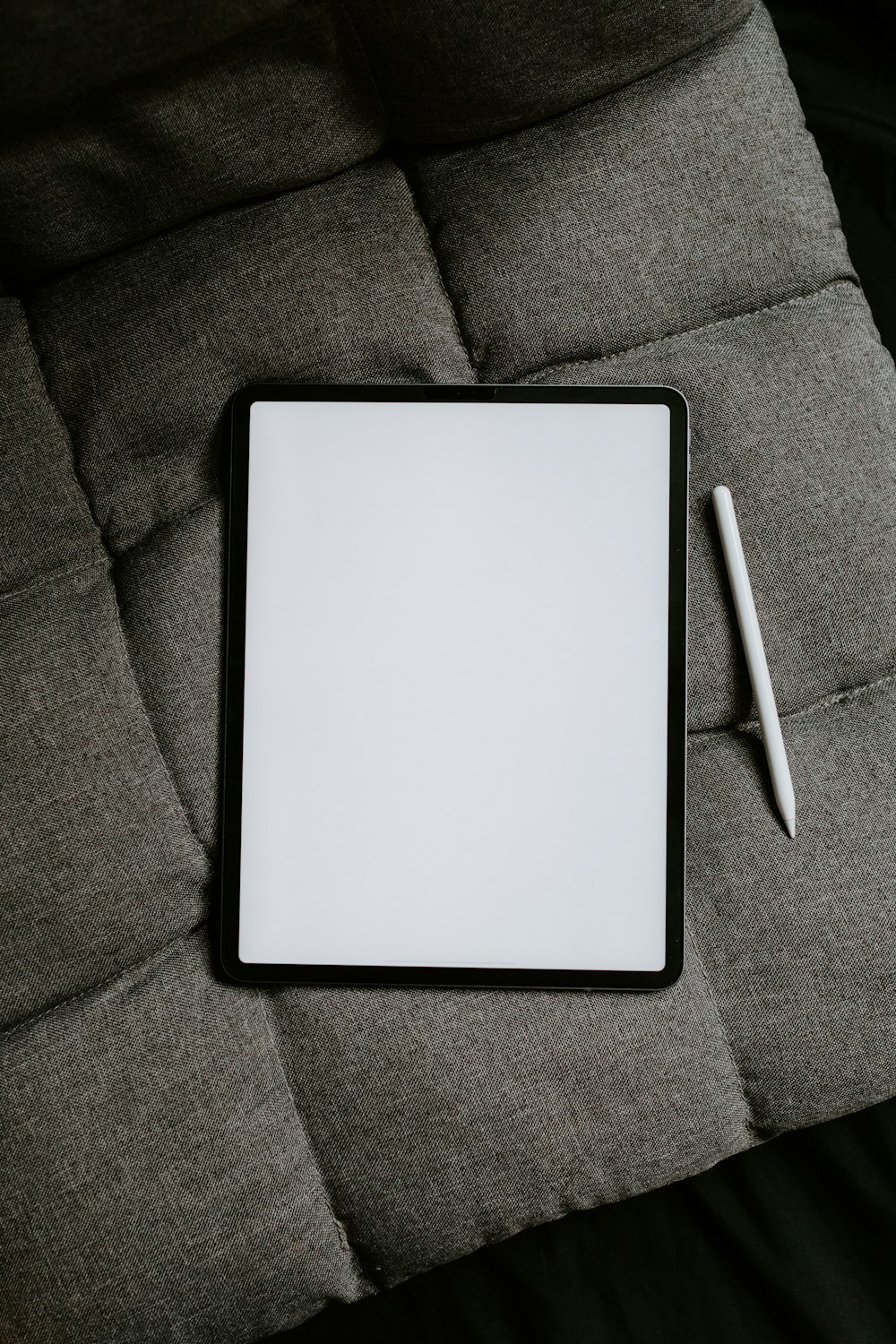 white tablet computer on gray textile