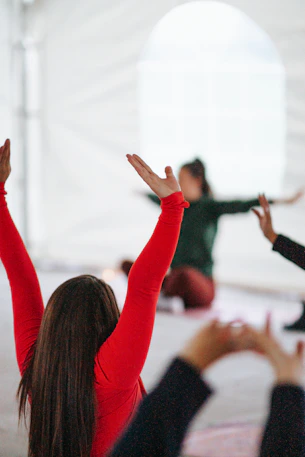 woman in red long sleeve shirt raising her hands