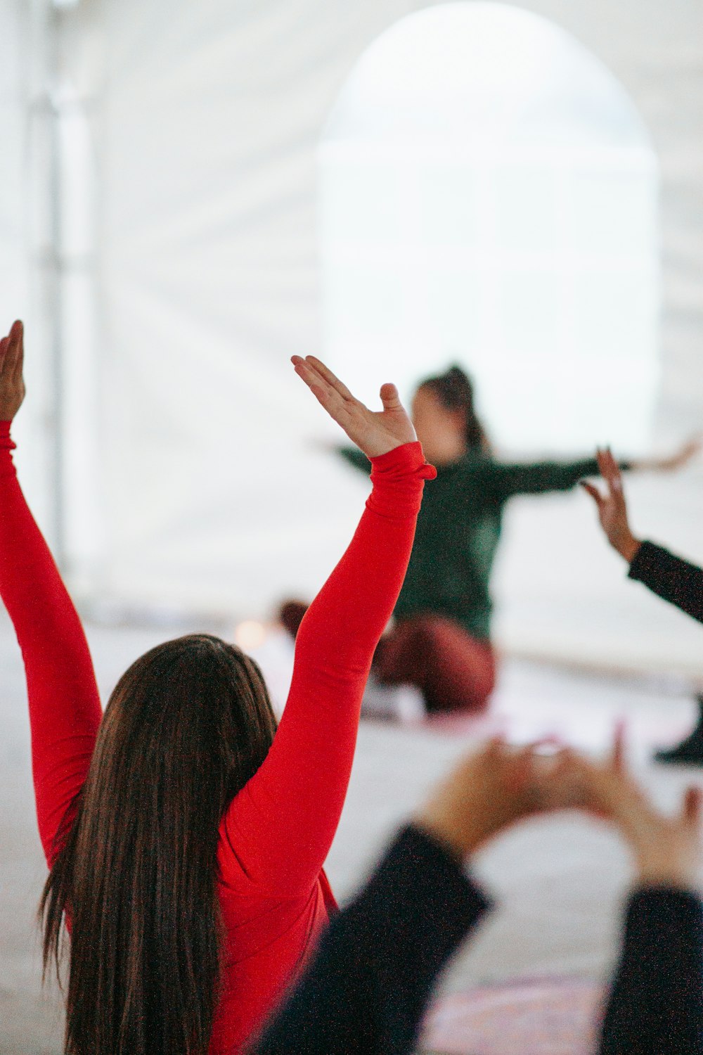 woman in red long sleeve shirt raising her hands