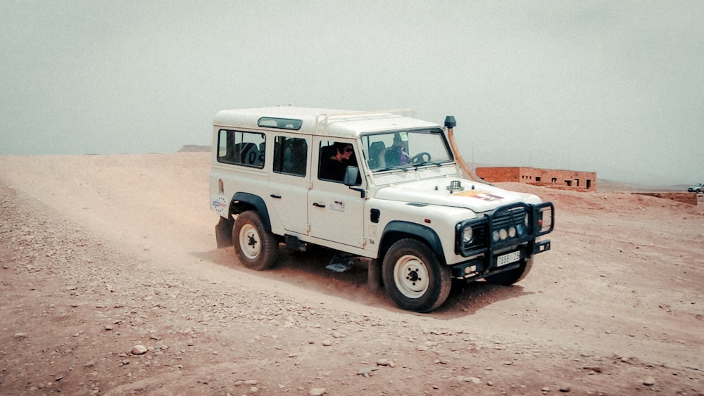 Weißer SUV tagsüber auf braunem Sand