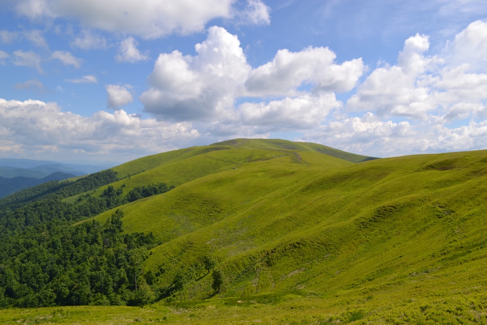 montagne verdi sotto nuvole bianche e cielo blu durante il giorno