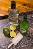 green glass bottle beside sliced lemon