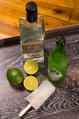 green glass bottle beside sliced lemon