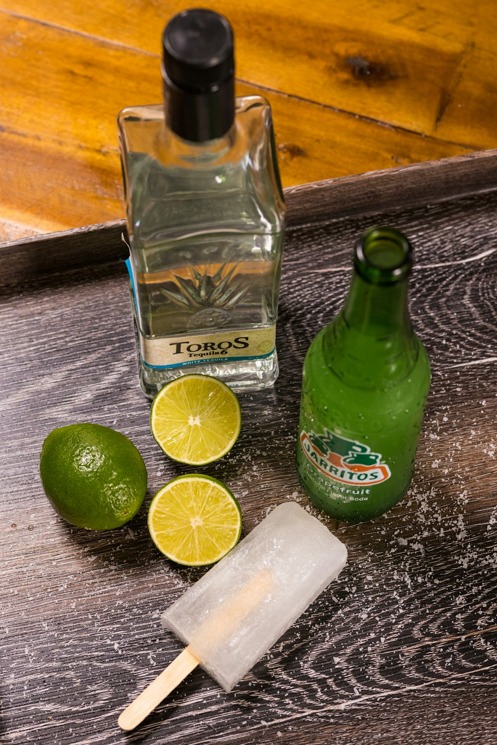 green glass bottle beside sliced lemon