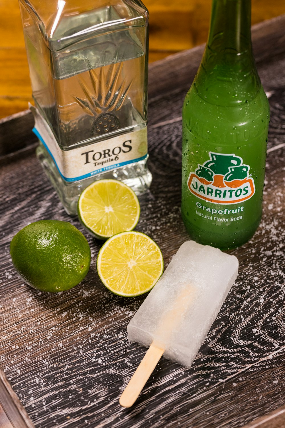grün-weiß etikettierte Flasche neben geschnittener Zitrone