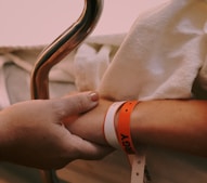 person wearing orange and white silicone band