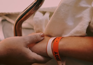 person wearing orange and white silicone band