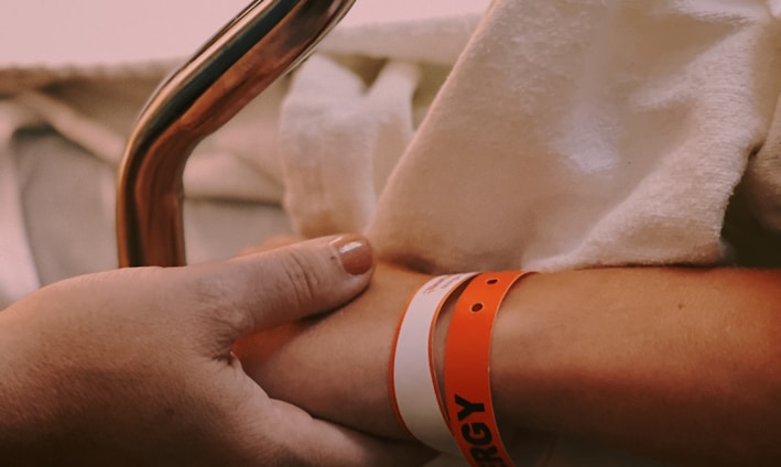 person wearing orange and white silicone band