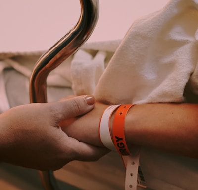 person wearing orange and white silicone band