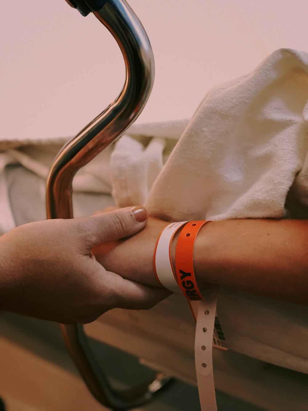 person wearing orange and white silicone band