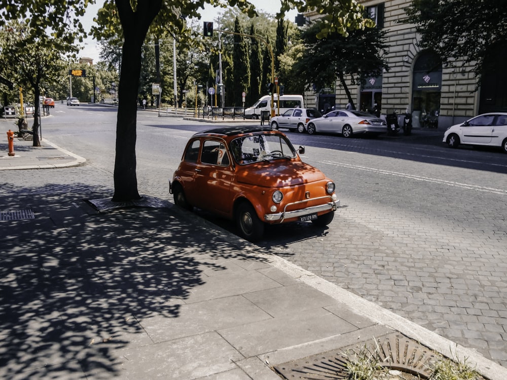 red car parked on sidewalk during daytime