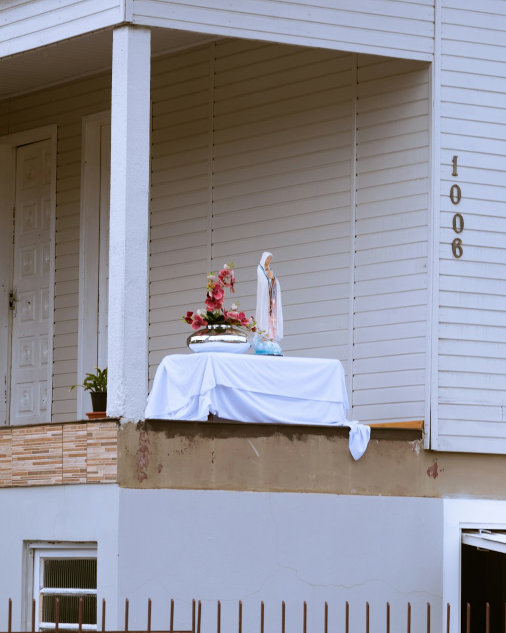 woman in white wedding gown sitting on white wooden window