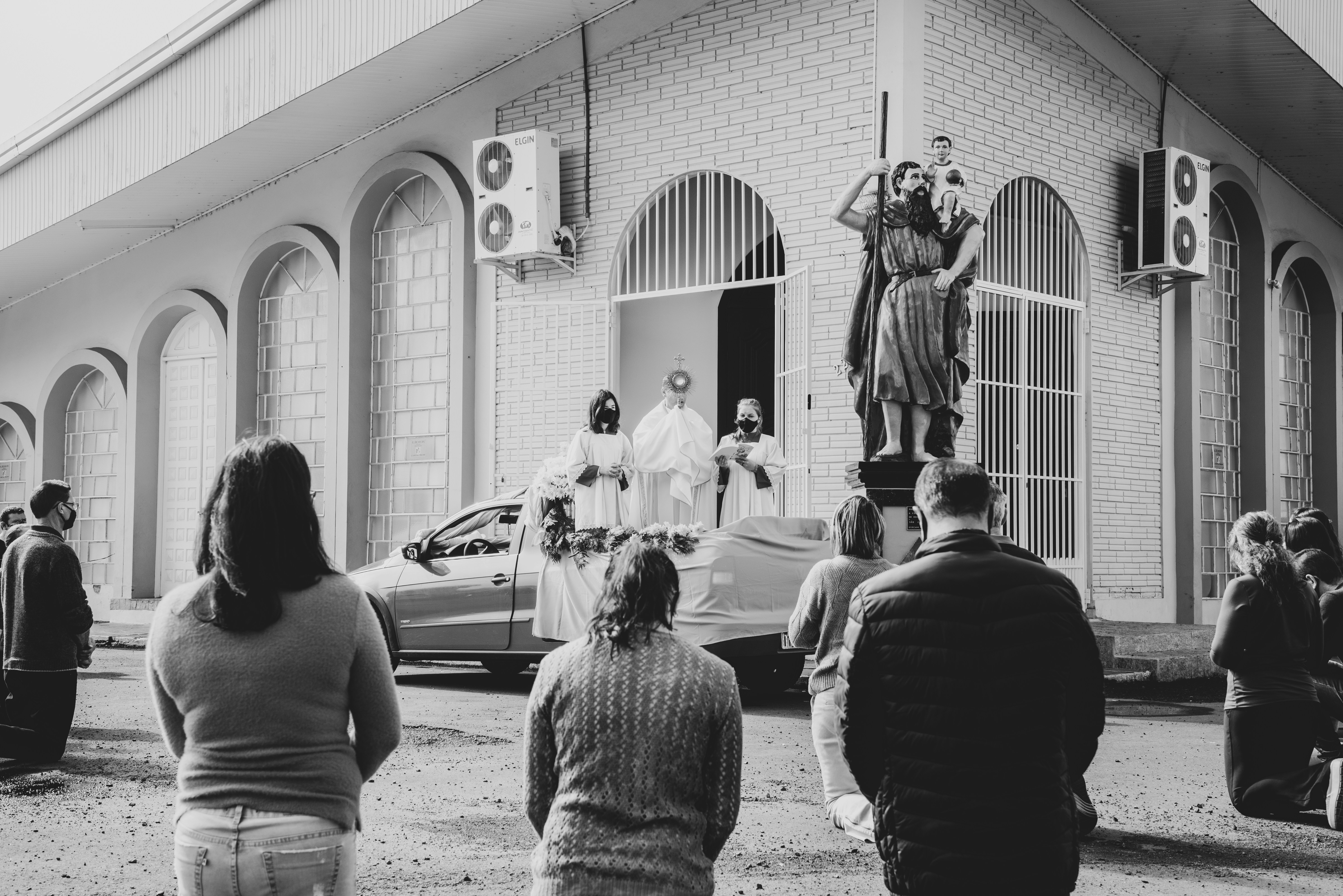 grayscale photo of people standing near car