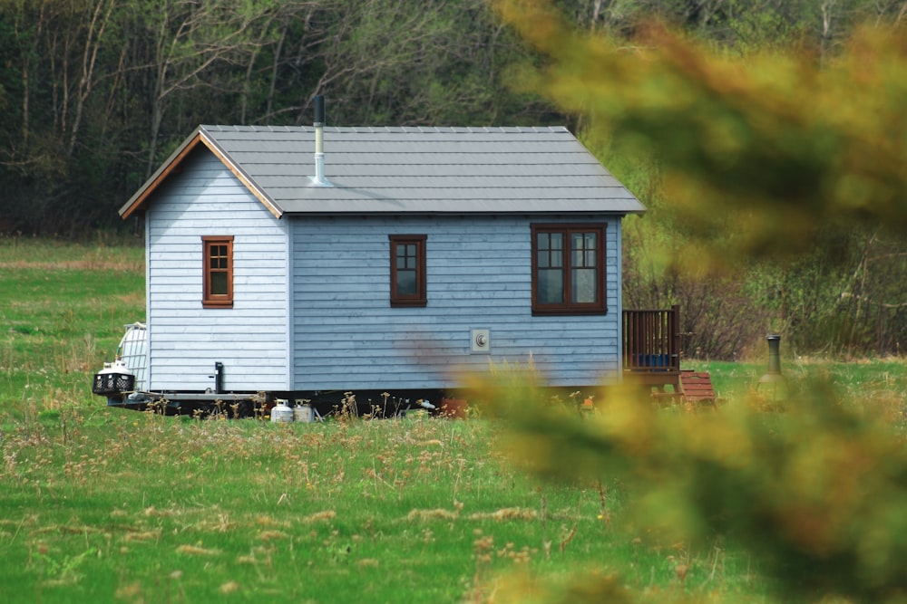 casa di legno bianca e gialla sul campo di erba verde durante il giorno