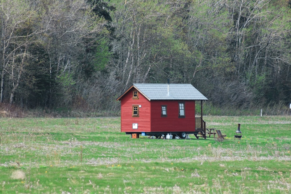 casa de madeira vermelha e branca no campo verde da grama