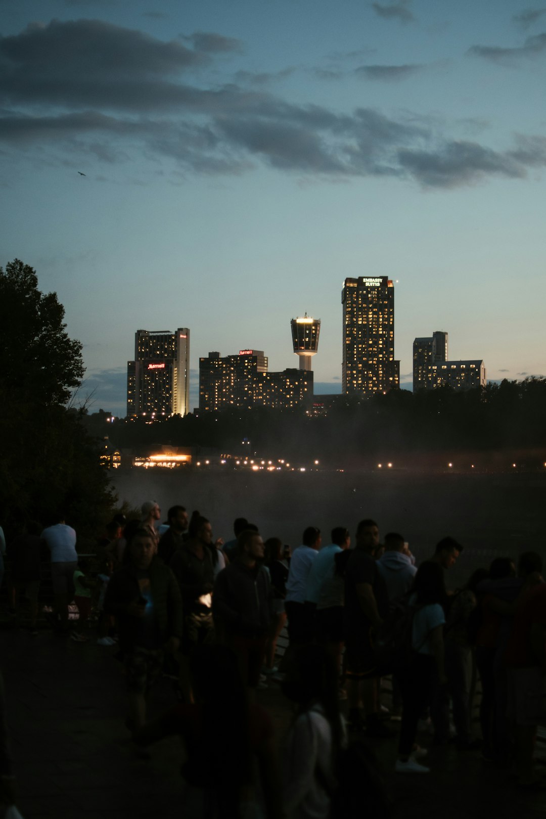 people standing near body of water during night time