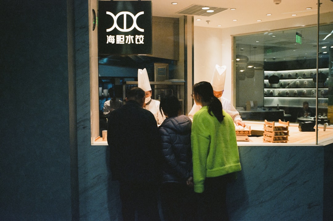 man in black jacket standing beside woman in green hoodie