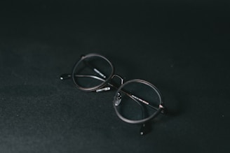 silver framed eyeglasses on black textile